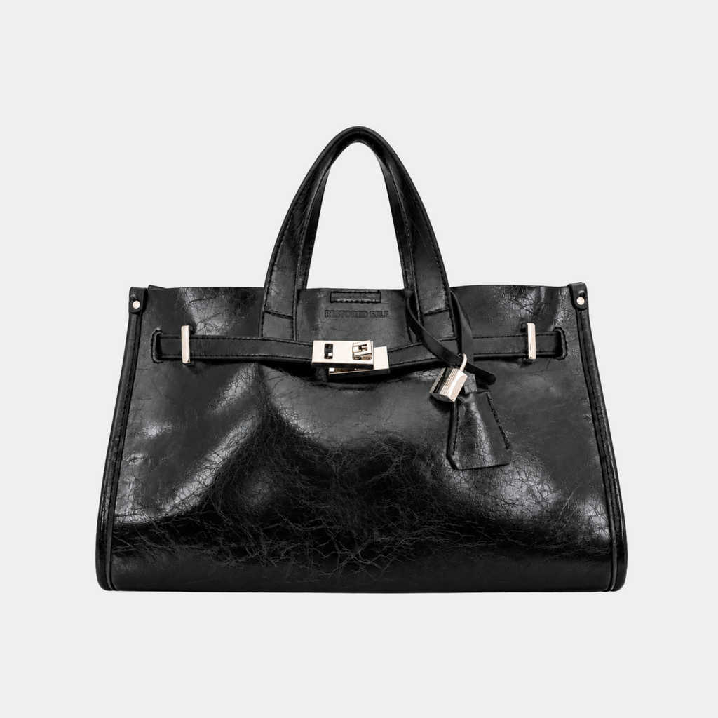 It Girl bag in Ink, black vegan leather satchel with silver belted lock closure, front view